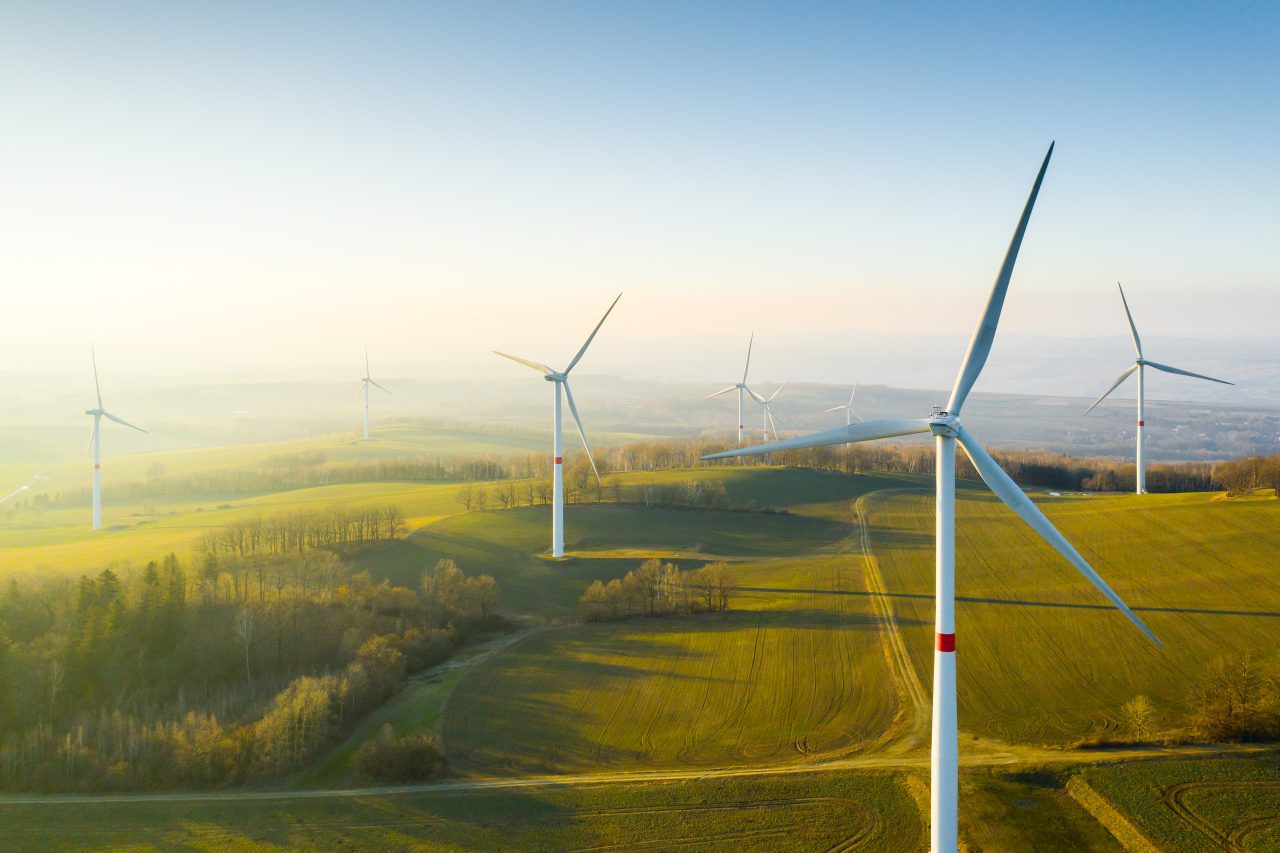 panoramic-view-of-wind-farm-or-wind-park-with-high-wind-turbines-for-generation-electricity-with-1-e1696237388844.jpg