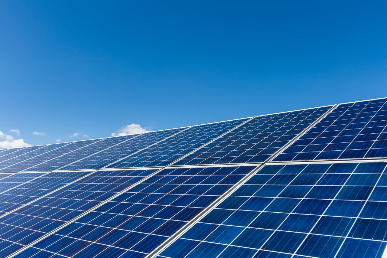 solar-panels-against-a-blue-sky-e1696032253767.jpg